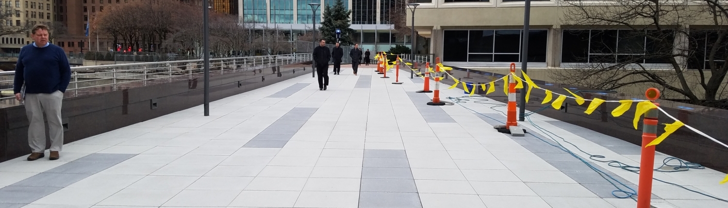 Pedestrian bridge pictured from onto of it looking toward a tall building