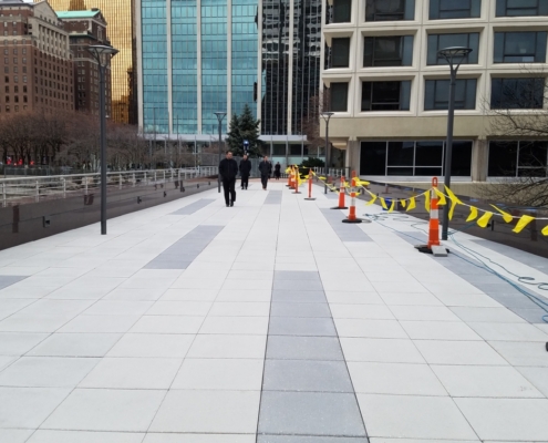 Pedestrian bridge pictured from onto of it looking toward a tall building