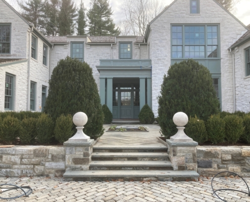 Entrance of the residence with stone steeps leading up the the stone house with a green door