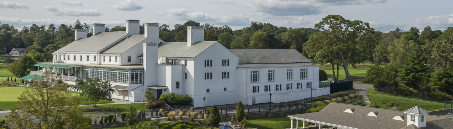 large landscape image of the pool deck along with the main building