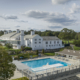 large landscape image of the pool deck along with the main building