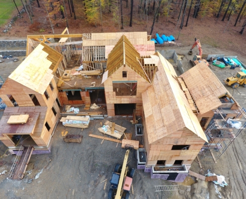 House under construction showing partially competed roof with some of its framing visible