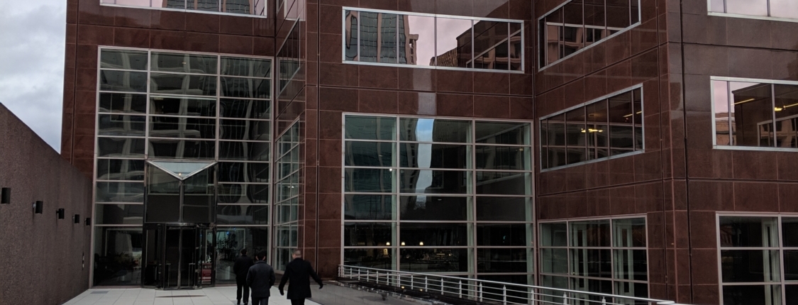 Pedestrian bridge pictured from onto of it looking toward a tall building