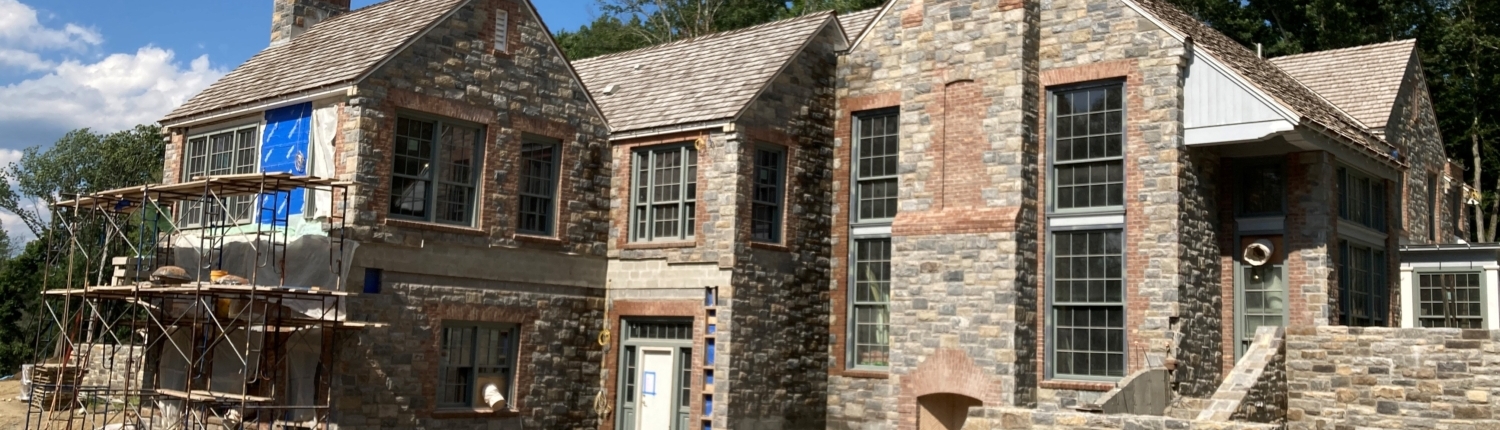 Rear of house with stone steps leading to raised area where house is